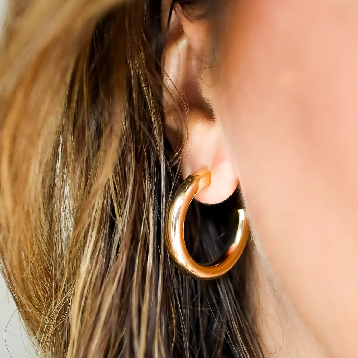 Medium Classic Hoop Earrings in 14K Yellow Gold, on ear | JJ Jewelry Miami