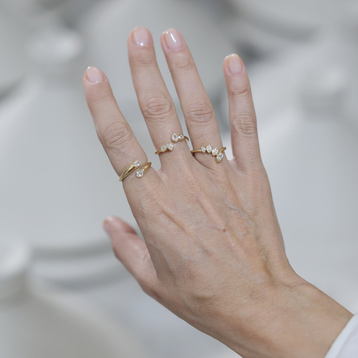 Open Bezel Pear and Emerald-Cut Diamond Ring in 18K Gold, side view | JJ Jewelry Miami