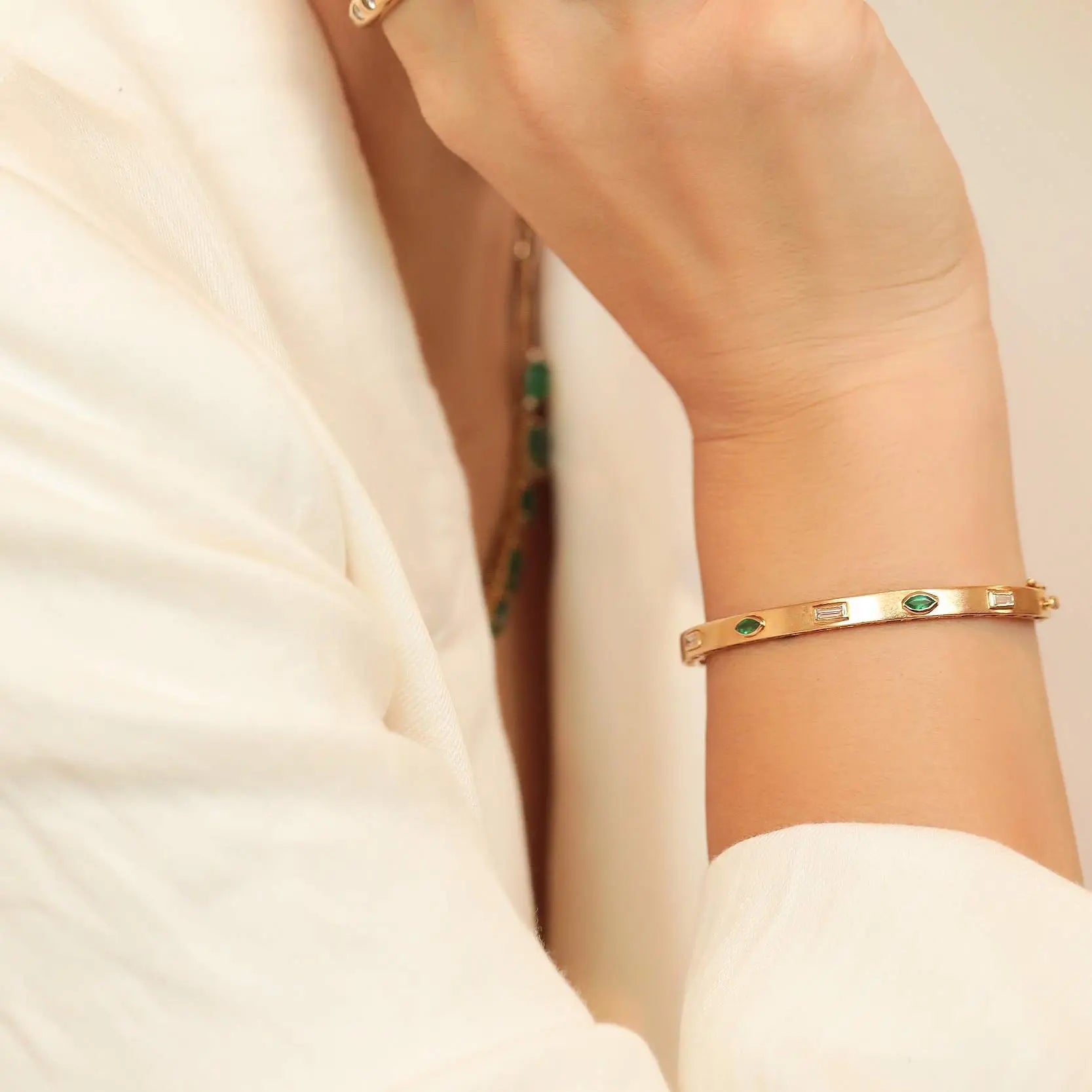 Bezel-set emerald and diamond bangle in 14K yellow gold by JJ Jewelry