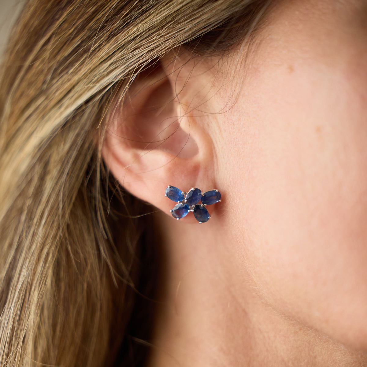 Blue Sapphire Flower Cluster Earrings in 18K White Gold, on ear | JJ Jewelry Miami